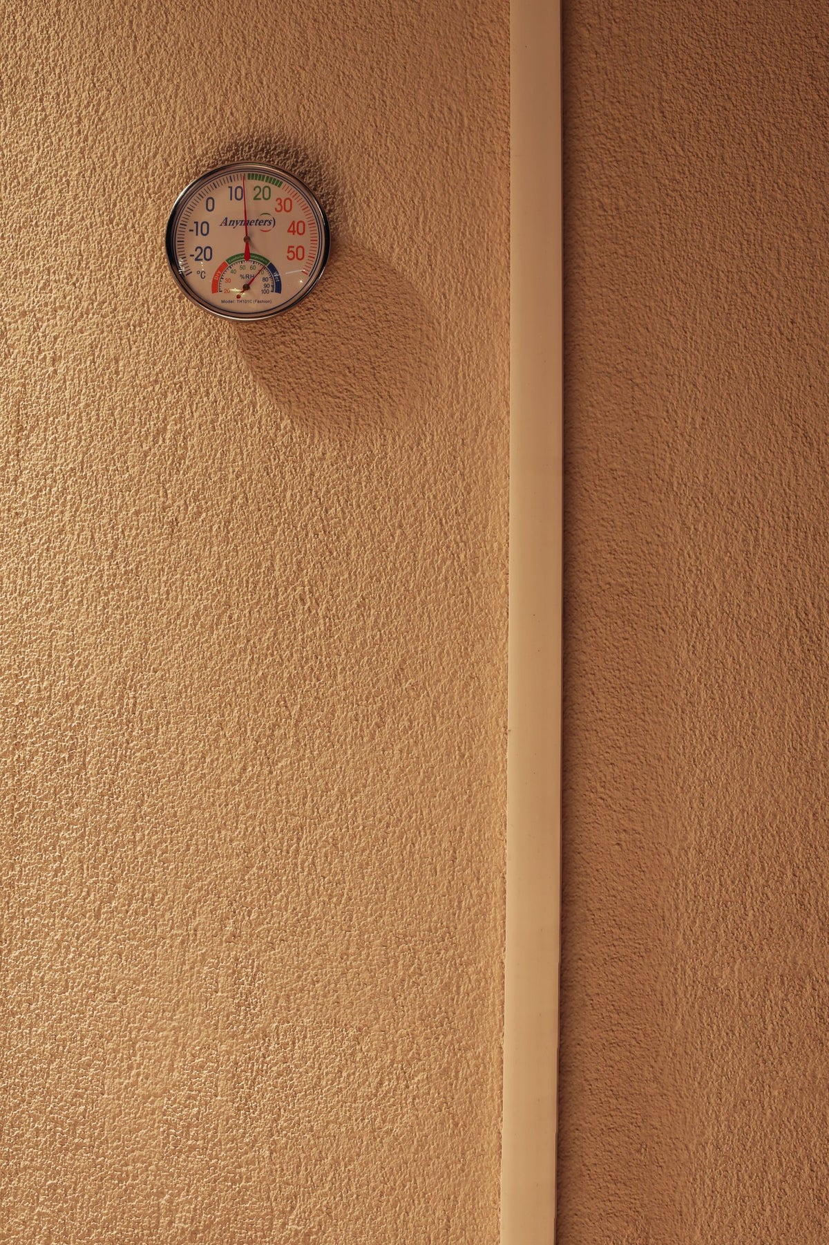Hygrometer aan een muur die temperatuur en luchtvochtigheid weergeeft