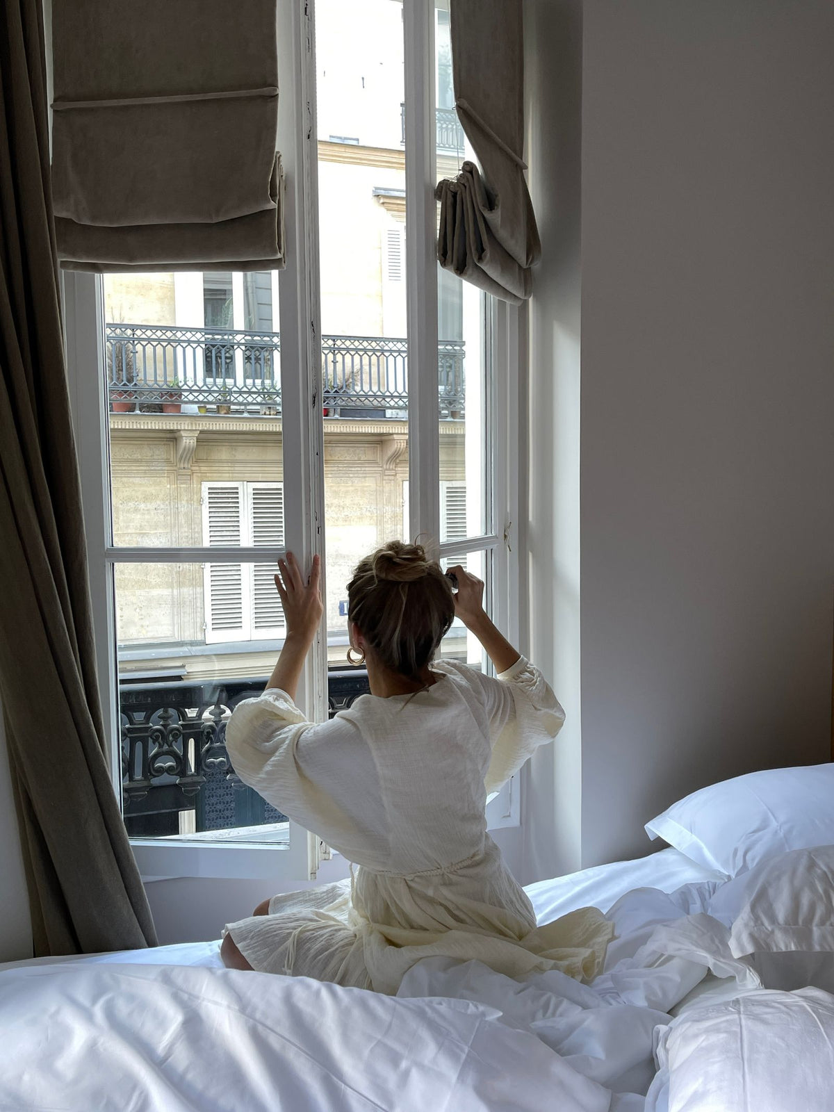 Vrouw die een raam in de slaapkamer opent om te ventileren