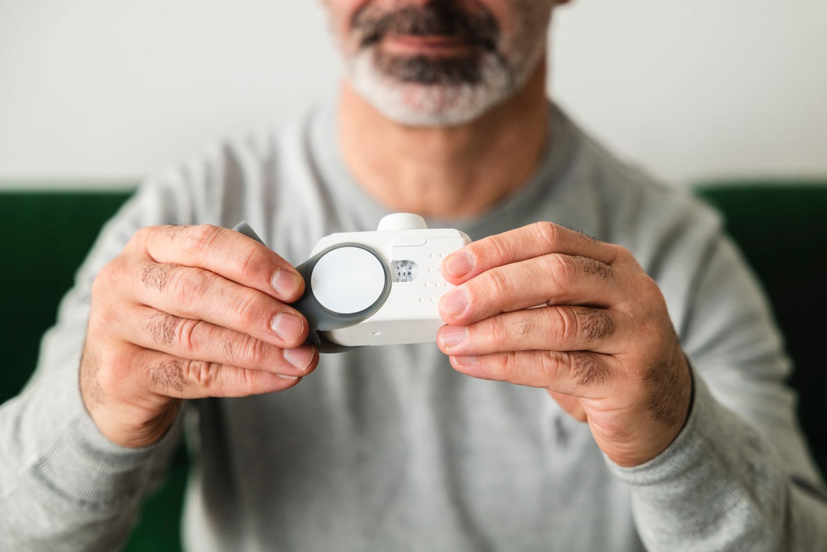 Man met een handheld luchtkwaliteitsmeter die de lucht meet