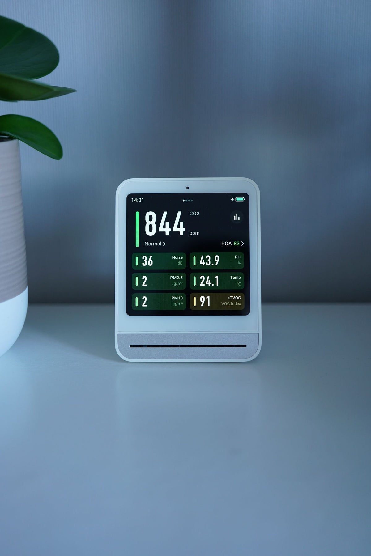 Moderne luchtkwaliteitsmeter met CO2-uitlezing op een bureau