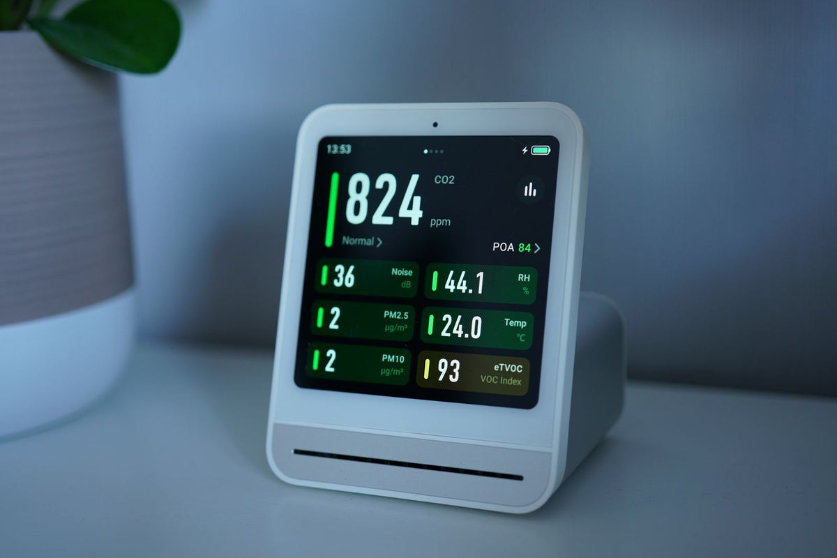 Digitale luchtkwaliteitsmeter met CO2-weergave op een tafel