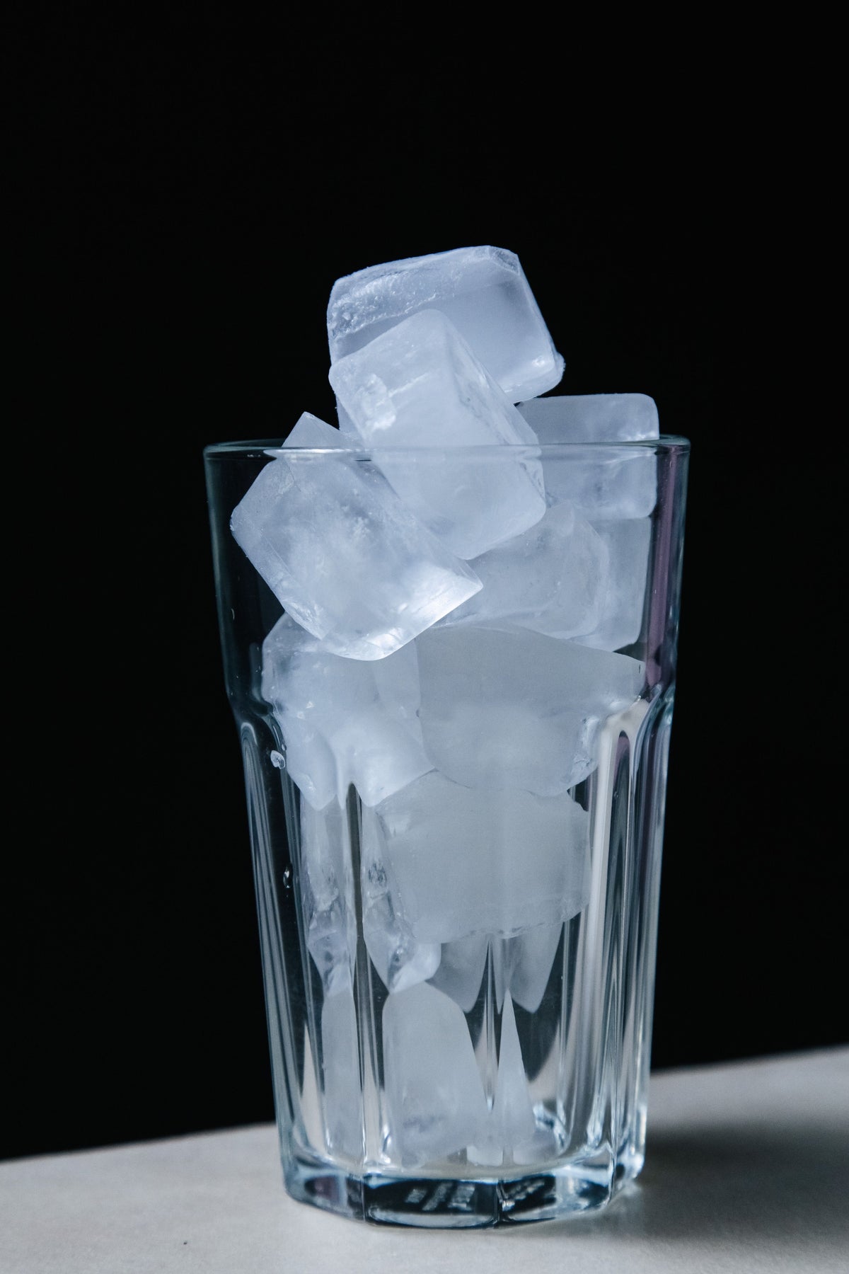 Glas water met ijsblokjes als symbool voor het water dat een aircooler gebruikt om te koelen